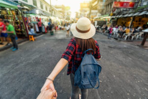 Back side of Young Asian traveling women leading by holding her