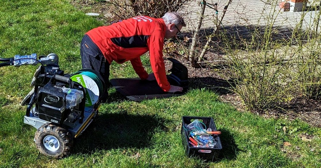 Dansk Robotklip tekniker arbejder med kabelnedlægning og ladestation i en kundehave.