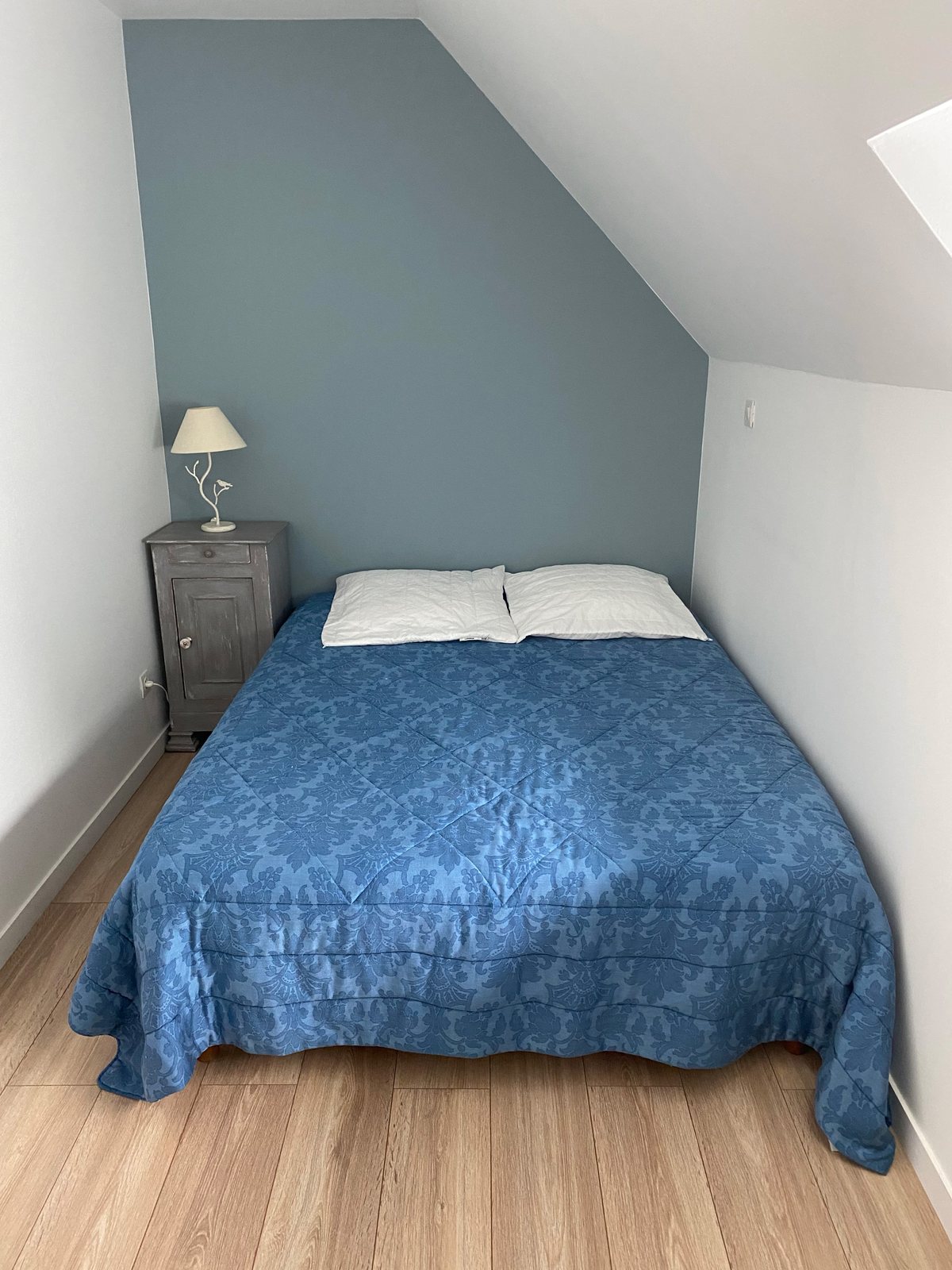 La chambre bleue sous les combles, lit double et fenêtre de toit