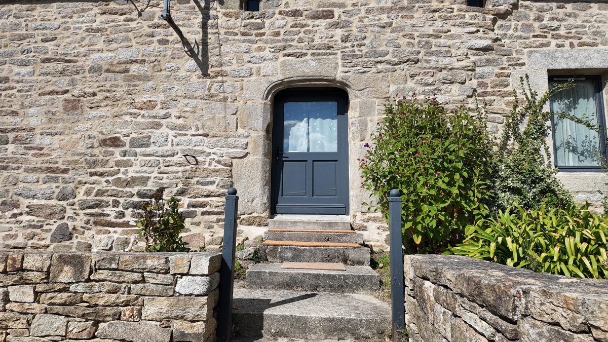 La porte d’entrée de Kervran, encadrée de granit, au-dessus de quelques marches de pierre