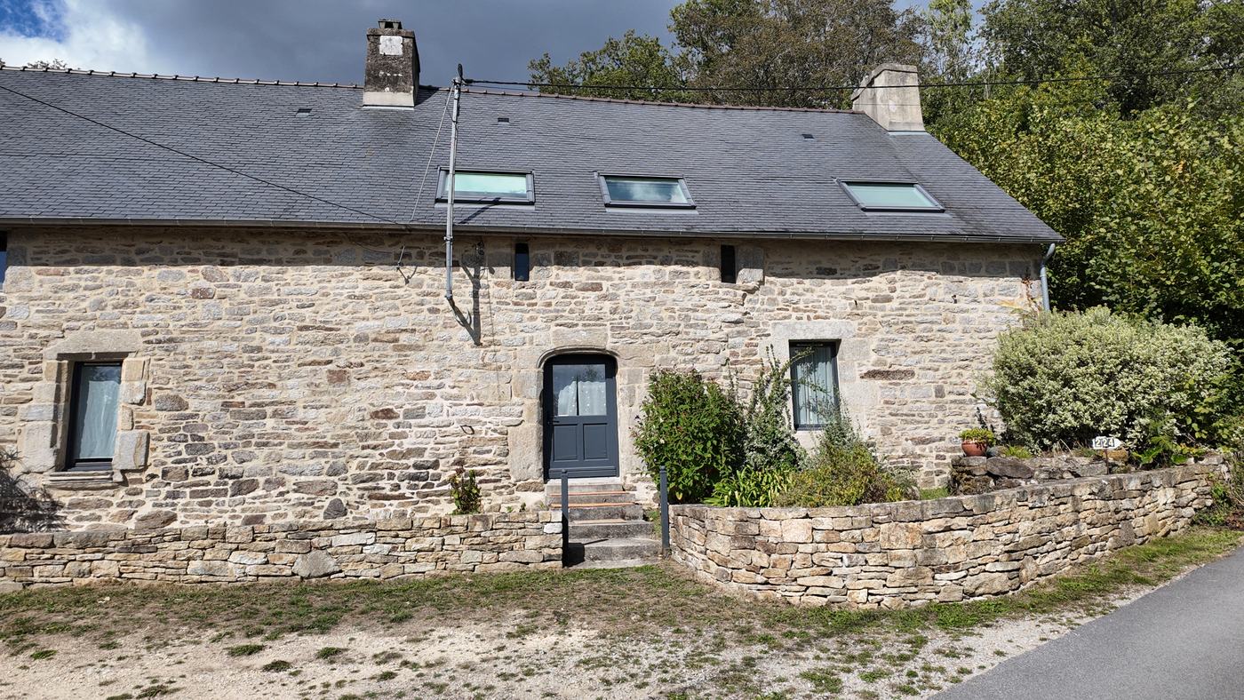 La longère vue d’ensemble, avec son toit d’ardoise et ses trois fenêtres de toit