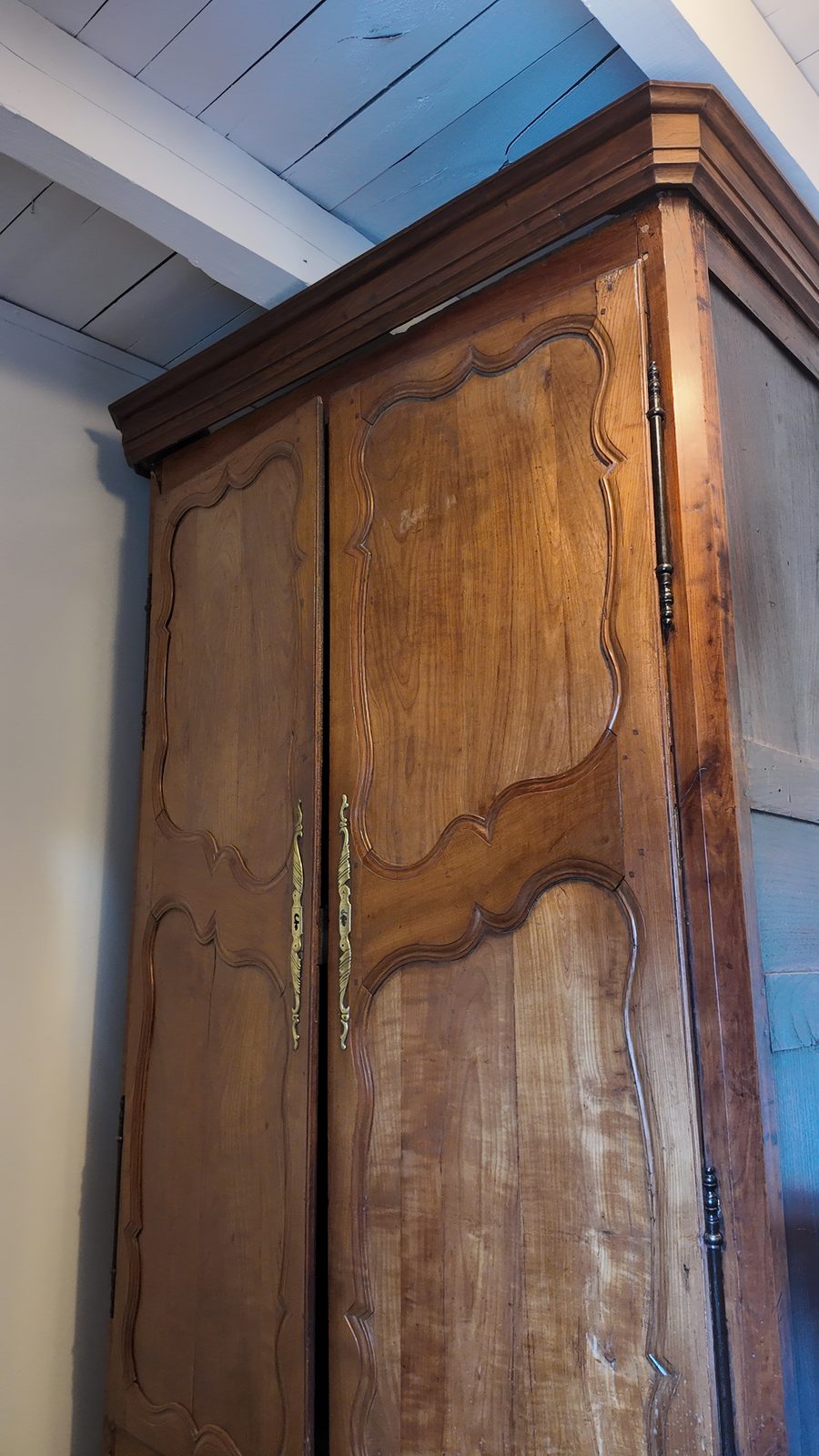 Une armoire bretonne ancienne en bois sculpté, contre le mur
