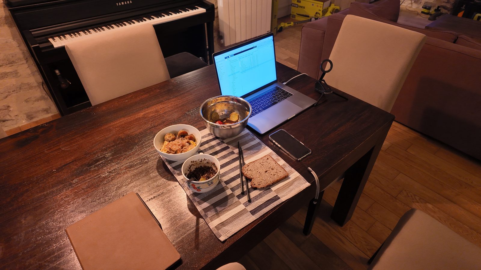 Un ordinateur portable et une tasse de café posés au bout de la grande table