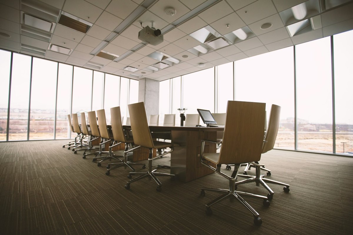 An empty boardroom table with chairs, waiting for the meeting
