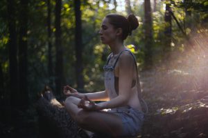 Woman meditating in nature; this is one way to practice calm parenting