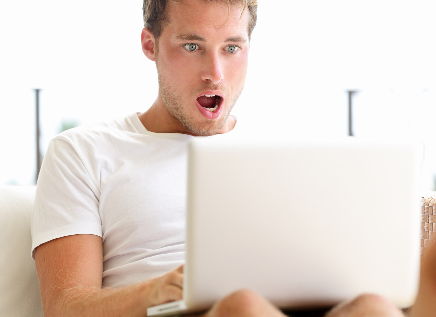Man staring at laptop in amazement