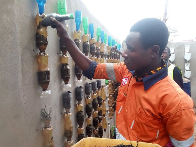 Soil is dug up from the ground and mixed with homemade compost to fill the containers. Tools are made from plastic bottles.