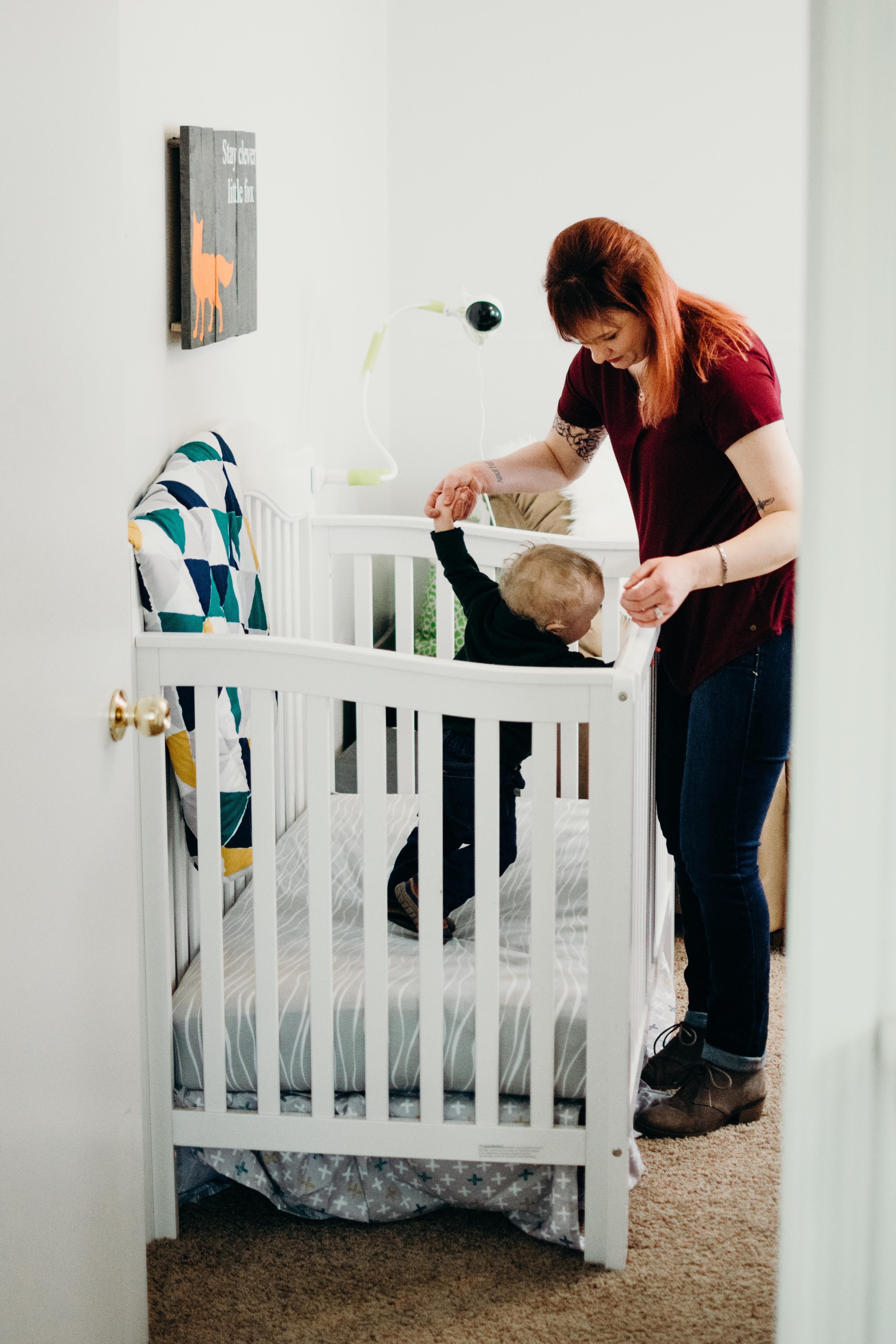 Baby standing hot sale in crib